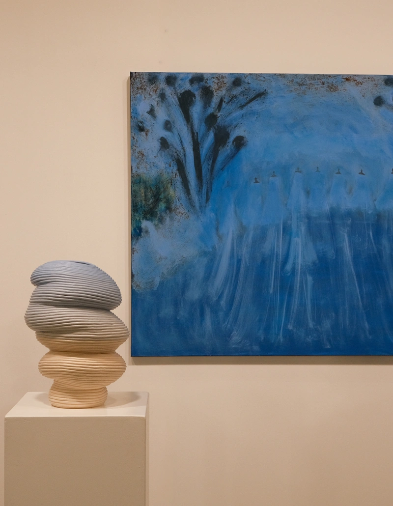 Large blue painting displayed alongside sculptural ceramic vessels at Aotearoa Art Fair 2026