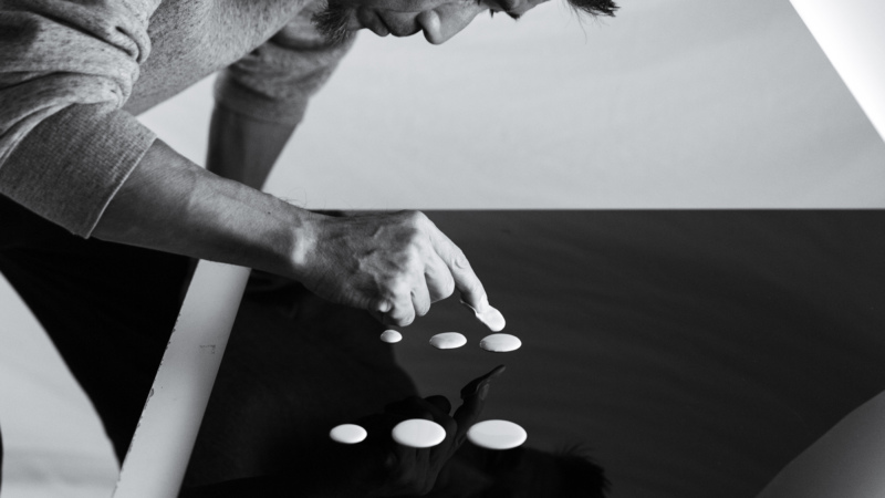 Man applying drops of paint to a surface